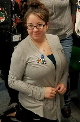 Author in a plain grey cardigan, blue tank top, and black pants.